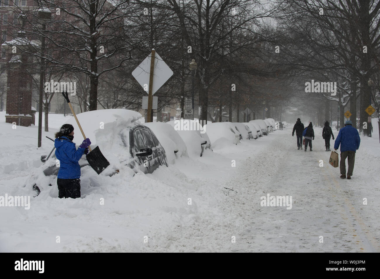 Die Bewohner gehen Sie Woodley Straße wie andere versuchen, ihre Autos im Nordwesten von Washington, DC, während einer Pause im Blizzard, die mehr als 20 cm Schnee auf die Hauptstadt der Nation am 23. Januar 2016 fallen wird. Die massive Blizzard hat den größten Teil der Ostküste bis zum Stillstand mit starken Winden und mehr als 30 Zentimeter Schnee in einigen Bereichen vorhergesagt. Foto von Pat Benic/UPI Stockfoto