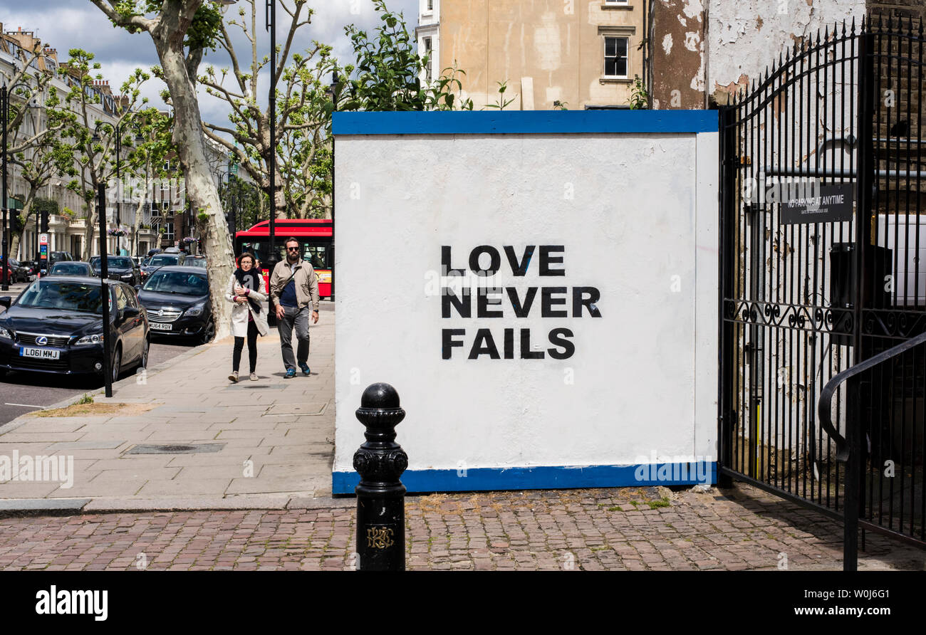 Der Bauzaun mit Die Liebe hört niemals auf, London, England, Großbritannien Stockfoto