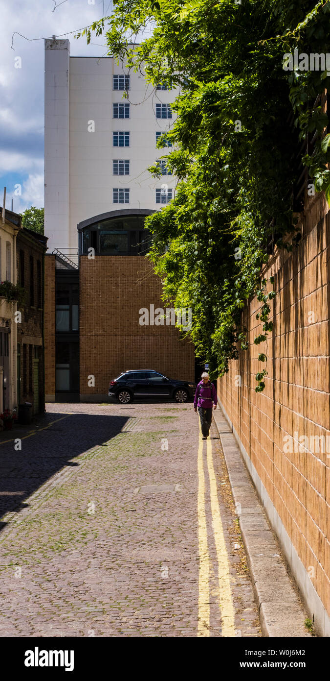 Person zu Fuß auf doppelten gelben Linien in Back Street, London, England, Großbritannien Stockfoto