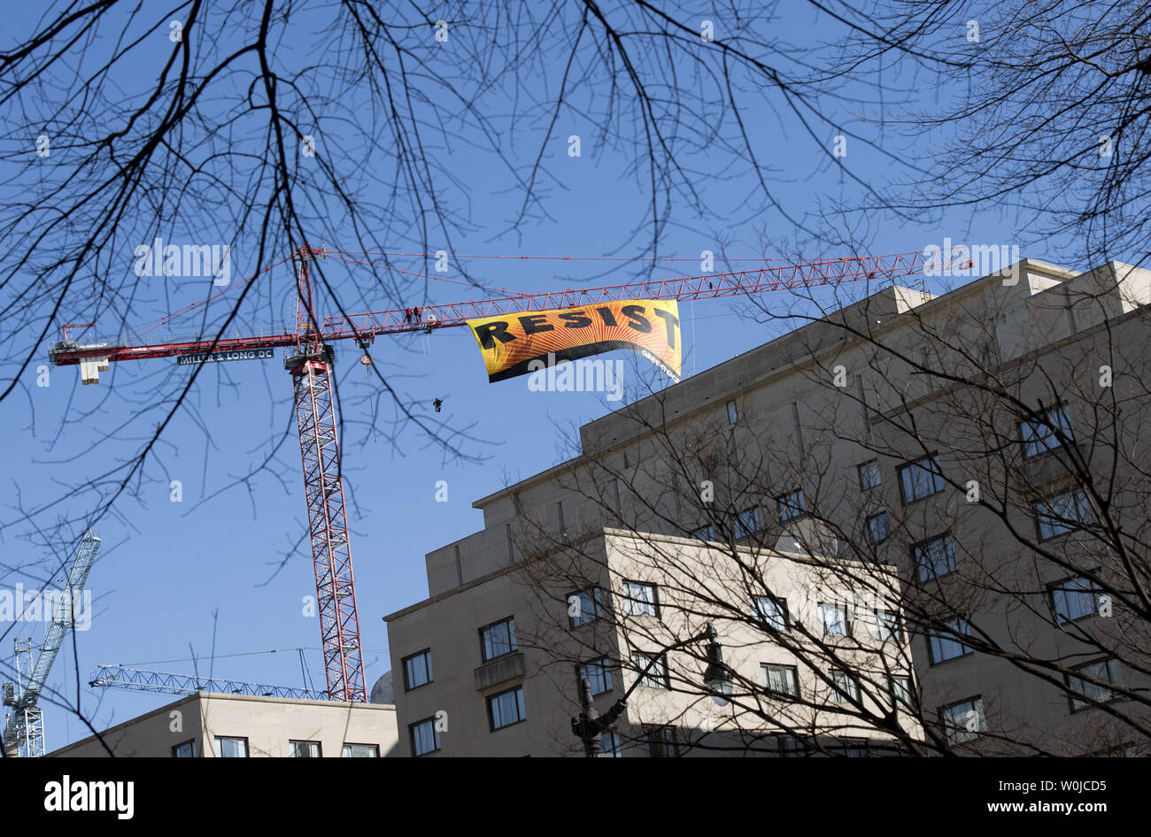 Greenpeace Aktivist hängen Sie ein Banner lesen das Wort Widerstehen von einem Kran in der Nähe des Weißen Hauses in Washington, D.C., am 25. Januar 2017. Foto von Kevin Dietsch/UPI Stockfoto