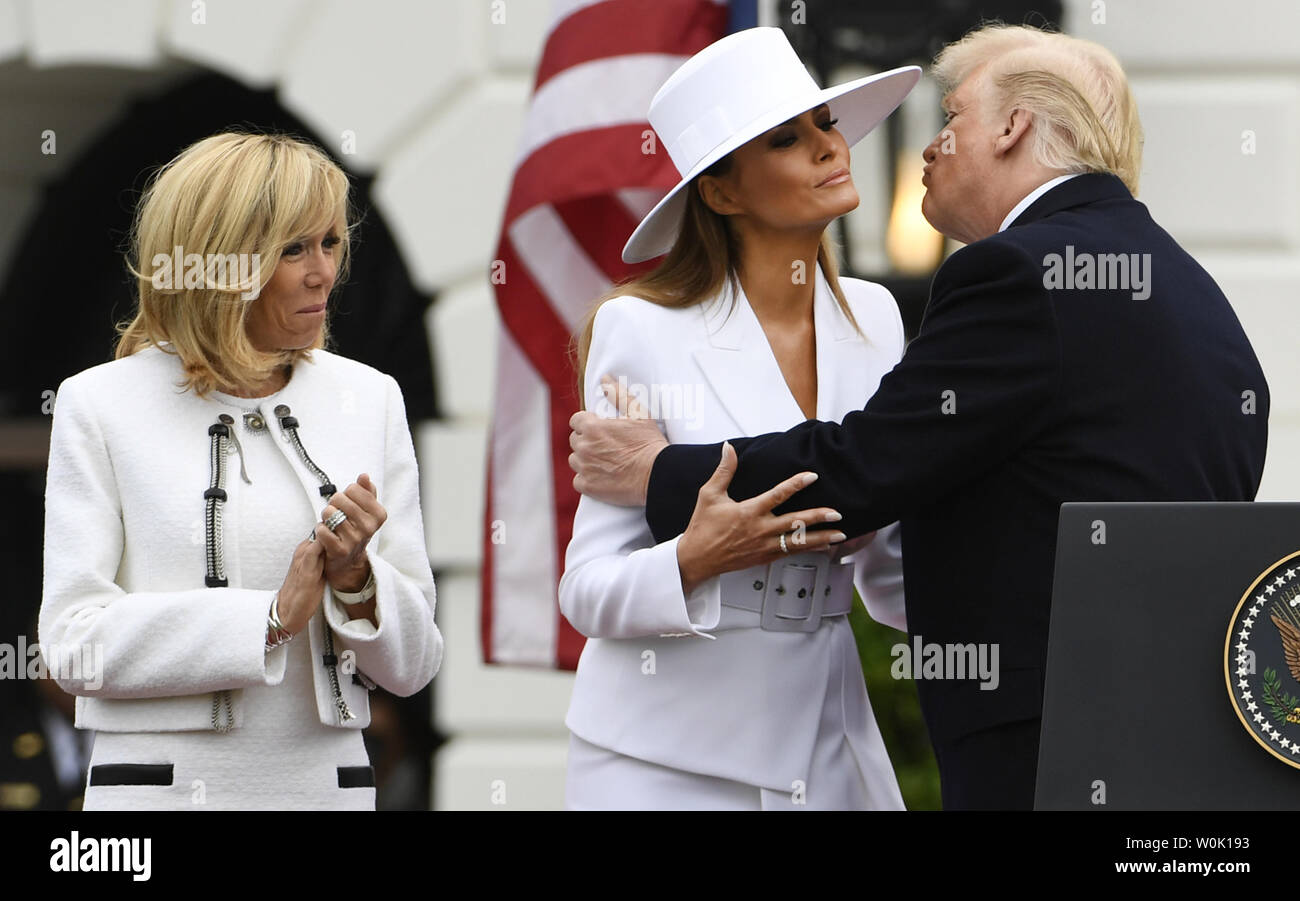 Präsident Donald Trump (R) umarmt und küsst Erste Dame Melania Trump als Ehefrau des französischen Präsidenten Emmanuel's Längestrich Brigitte zum Abschluss der Staatsbesuch Begrüßung im Weißen Haus, April 24, 2018, in Washington, DC, applaudiert. Die Staats- und Regierungschefs erwartet werden, den Handel, den Iran, den Klimawandel zu diskutieren, Nordkorea, Russland unter anderem. Foto von Mike Theiler/UPI Stockfoto