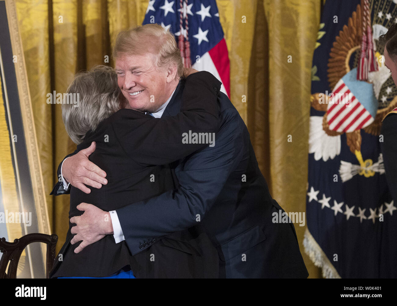 Präsident Donald Trump Umarmungen Pauline Lyda Brunnen Conner die Witwe von Armee erste Lt Garlin M. Conner, der Trumpf posthum die Ehrenmedaille verliehen, während einer Zeremonie im Osten Zimmer im Weißen Haus in Washington, D.C. am 26. Juni 2018. Conner, ein Eingeborener von Kentucky, wird für seine heroischen Taten im Kampf im Zweiten Weltkrieg geehrt Andere Conner's Auszeichnungen den Distinguished Service Cross, vier Silber Stern Medaillen, eine Bronze Star und drei Purple Hearts für Verletzungen im Kampf gelitten. Foto von Kevin Dietsch/UPI Stockfoto