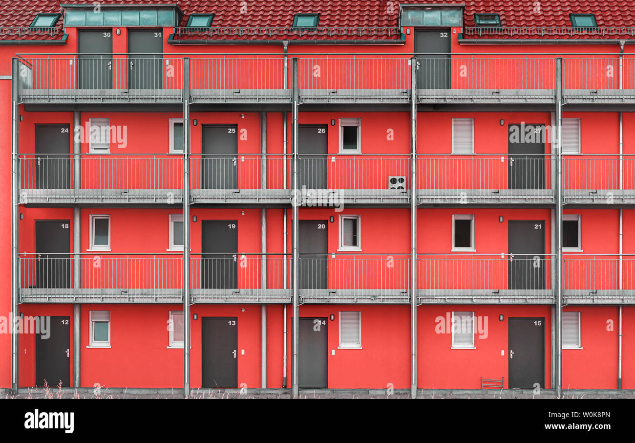 Bunte Fassade einer Wohnung Gebäude mit roten Wänden, grau Türen und Fliesen Dach, in einem Wohnviertel in Schwäbisch Hall, Deutschland. Stockfoto