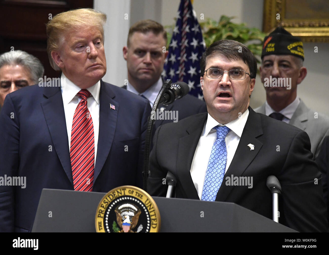 Präsident Donald Trump (L) Hört sich Bemerkungen Veteran-leitung Sekretär Robert Wilkie, vor der Unterzeichnung eines Executive Order über den Selbstmorden von Kriegsveteranen, im Weißen Haus, Washington, DC, 5. März 2019. Eine "Nationale Roadmap zu den Veteranen befähigen und Ende Selbstmord' wird die Epidemie der Selbstmorde von Mitgliedern des US-Militärs. Foto von Mike Theiler/UPI Stockfoto