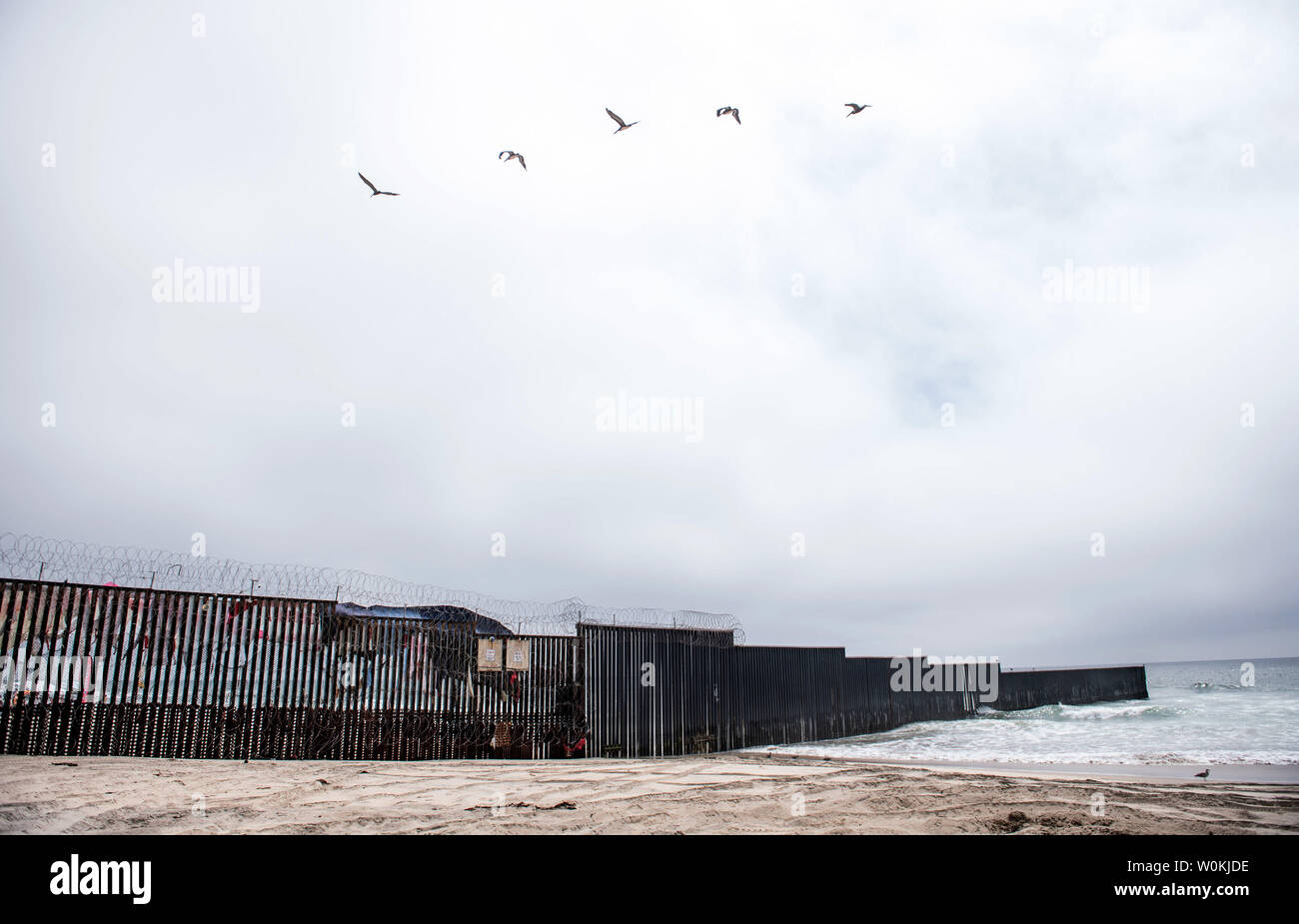 Vögel fliegen über den USA-Mexiko Grenzzaun, wie es erstreckt sich in den Pazifischen Ozean auf internationaler Freundschaft Park im Imperial Beach, Kalifornien am 10. Juni 2019. Foto von Kevin Dietsch/UPI Stockfoto