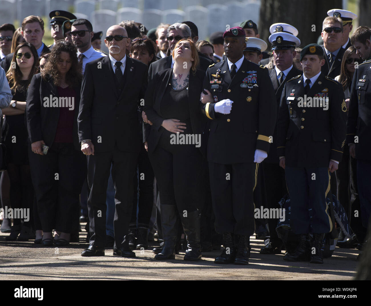 Alexandra McClintock (C) reagiert bei der Beerdigung ihres Mannes U.S. Army Sgt. First Class Matthew F. McClintock, auf dem Arlington National Cemetery in Arlington, Virginia, am 7. März 2015. SFC McClintock, ein U.S. Army Special Forces Soldat, wurde in der Tätigkeit am Dienstag getötet, 5. Januar 2016, in Afghanistan. Foto von Kevin Dietsch/UPI Stockfoto