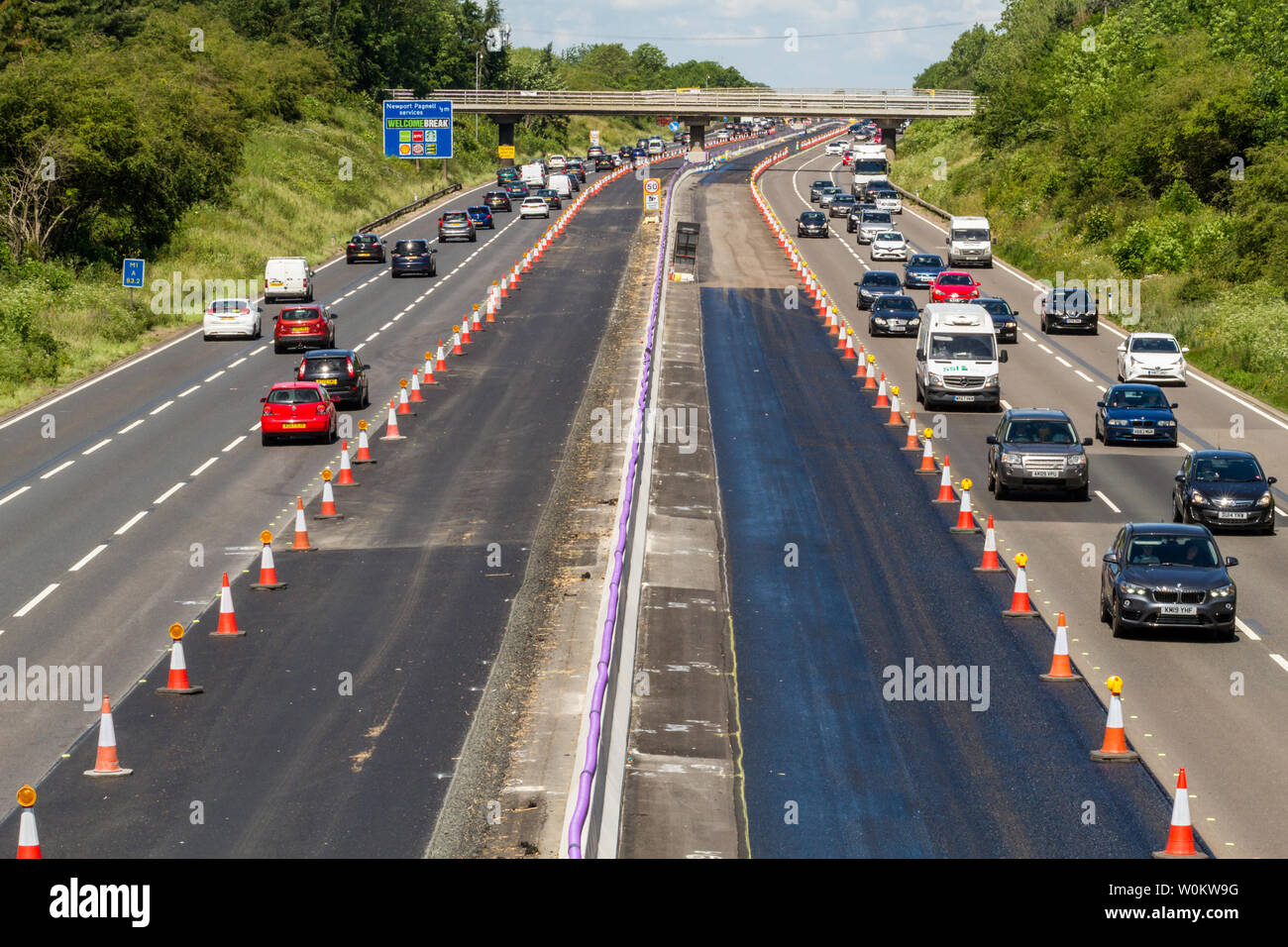 Entwicklung von Smart Autobahn an der Ausfahrt 14 der M1 mit dem charakteristischen langen Purple Power Kabel das zentrale Reservierung, Großbritannien Stockfoto