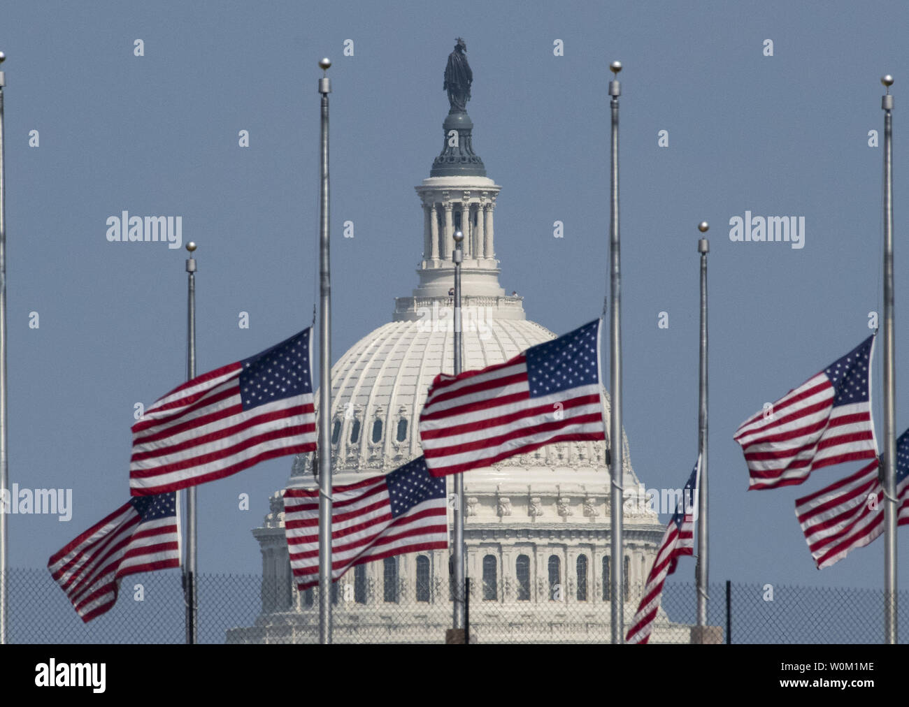 Mit dem U.S. Capitol im Hintergrund die Fahnen am Washington Monument fliegen zum halben - Personal zu Ehren von Senator John McCain, in Washington am 28. August 2018. Nach dem Druck aus dem Kongress und der Öffentlichkeit, Präsident Donald Trump umgekehrt seine Entscheidung und bestellt die Flaggen im Weißen Haus und anderswo bei der Hälfte zu fliegen - Personal bis McCain begraben ist. Foto von Pat Benic/UPI Stockfoto