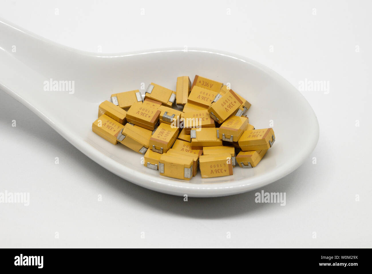 Tantal-Chip-SMD-Kondensatoren auf einem Keramiklöffel, elektronische Bauteile Stockfoto