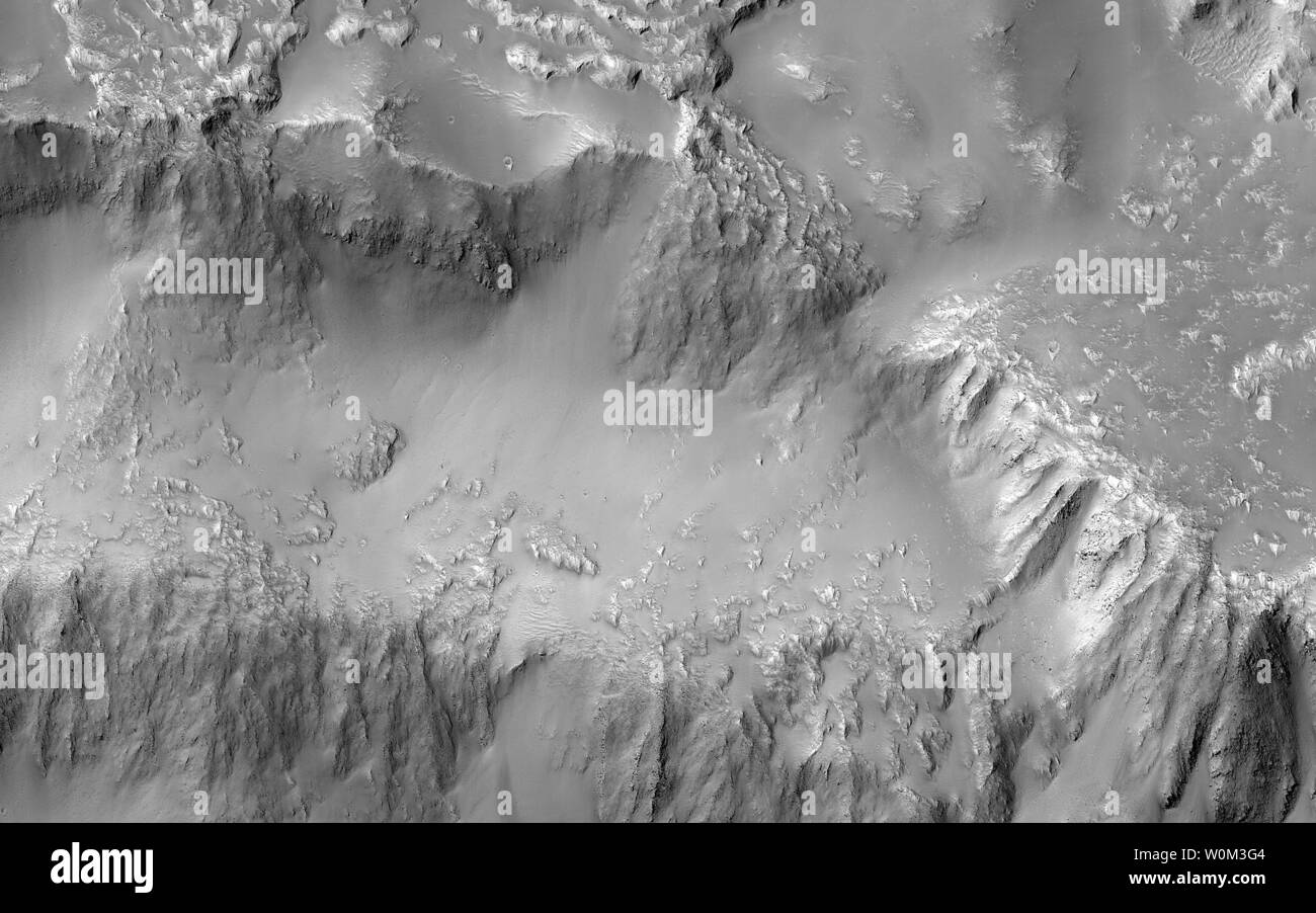 Verschiedene Forscher beschäftigen sich oft mit der Quest für fließendes Wasser auf dem Mars. Dieses Bild von der NASA Mars Reconnaissance Orbiter (MRO), zeigt jedoch eines der vielen Beispiele vom Mars, wo Lava (wenn es geschmolzen war) verhielt sich, in ähnlicher Weise zu flüssigem Wasser. Dieses Bild umfasst die drei Wasserfälle in der nördlich-zentralen Region der Kraterwand. Die Lavaströme und fällt unterscheiden sind gröber als die ursprünglichen Merkmale, die glatt und knorrigen sind. In einer Nahaufnahme hat der rau texturierte Lavastrom im Norden die Kraterwand an einer Engstelle verletzt wo es dann d Kaskaden Stockfoto