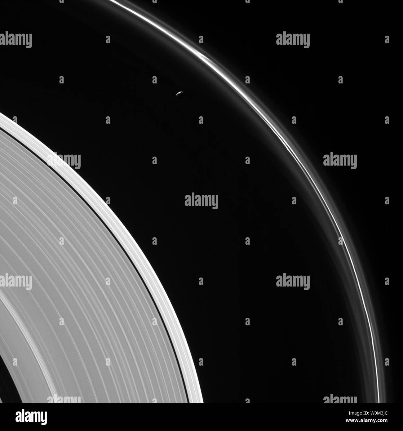Die dünne Splitter des Saturnmondes Prometheus lauert in der Nähe von geisterhaften Strukturen in Saturns schmale F-Ring in diesem Mai 13, 2017, Ansicht von der NASA-Raumsonde Cassini. Viele schwach und wispy Funktionen des schmalen Ring ergeben sich durch die Gravitation mit Prometheus (86 km oder 53 Meilen über). Die meisten der Oberfläche des kleinen Mondes ist in der Finsternis durch die Anzeigen von Geometrie hier. Auch hier ist ein deutlicher Unterschied in der Helligkeit zwischen dem äußeren Abschnitt des Saturn ein Ring (links der Bildmitte) und der Rest der Ring, inneren zum Keeler Gap (links unten). NASA/UPI Stockfoto