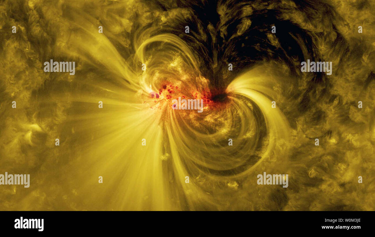 Am 5. Juli 2017, Solar Dynamics Observatory der NASA beobachtet eine aktive Region - ein Bereich, in die intensive und komplexe magnetische Felder - in den Blick auf die Sonne. Die Satelliten fortgesetzt der Region zu verfolgen und es wuchs und schließlich gedreht, die in der gesamten Sun und aus dem am 17. Juli drehen. Dieses Bild zeigt eine überlagerte Ansicht der Sonnenfleck im Sichtbaren und extreme UV-Licht, helle Spulen über das aktive Region-Teilchen spiralförmig entlang der Magnetfeldlinien. NASA/UPI Stockfoto