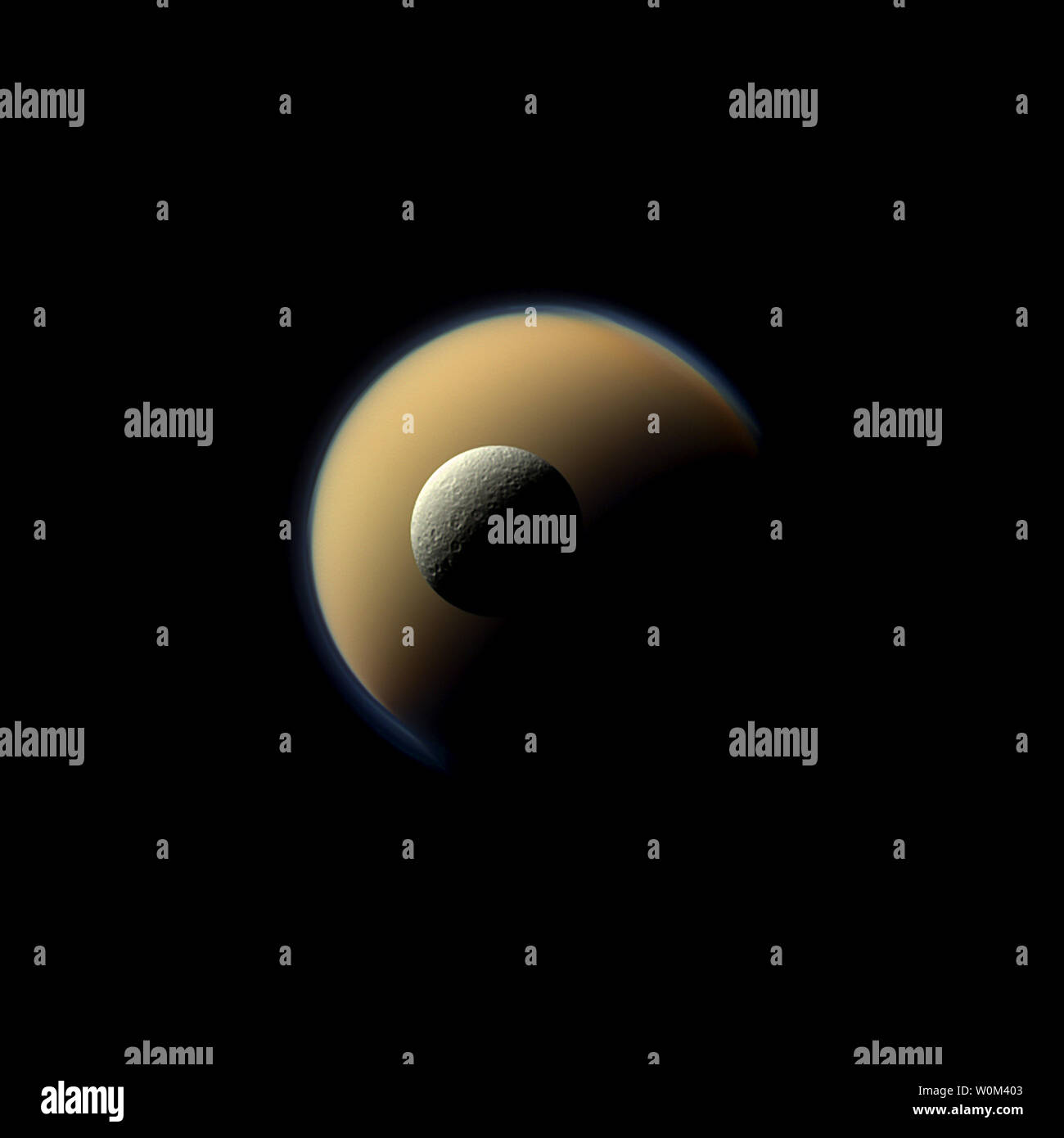 Saturn der größte und zweitgrößte Monde, Titan und Rhea, erscheinen in dieser true-color Szene auf der jeweils anderen von der NASA-Raumsonde Cassini gestapelt werden. Der Norden polar Haube kann auf Titan (3200 Meilen oder 5150 Kilometer quer durch) erscheinen als freistehende Schicht an der Spitze des Mondes auf der oberen rechten gesehen werden. Diese Ansicht, die am 23. Dezember 2013 genommen, schaut in Richtung der Saturn zugewandten Seite von Rhea. Am 15. September 2017, nach zwei Jahrzehnten im Raum, der NASA-Raumsonde Cassini hat seinen endgültigen Ansatz zu Saturn, tauchen in die Atmosphäre des Planeten. Seit ihrer Ankunft im Jahr 2004, die Cassini-Huygens-Mission Stockfoto