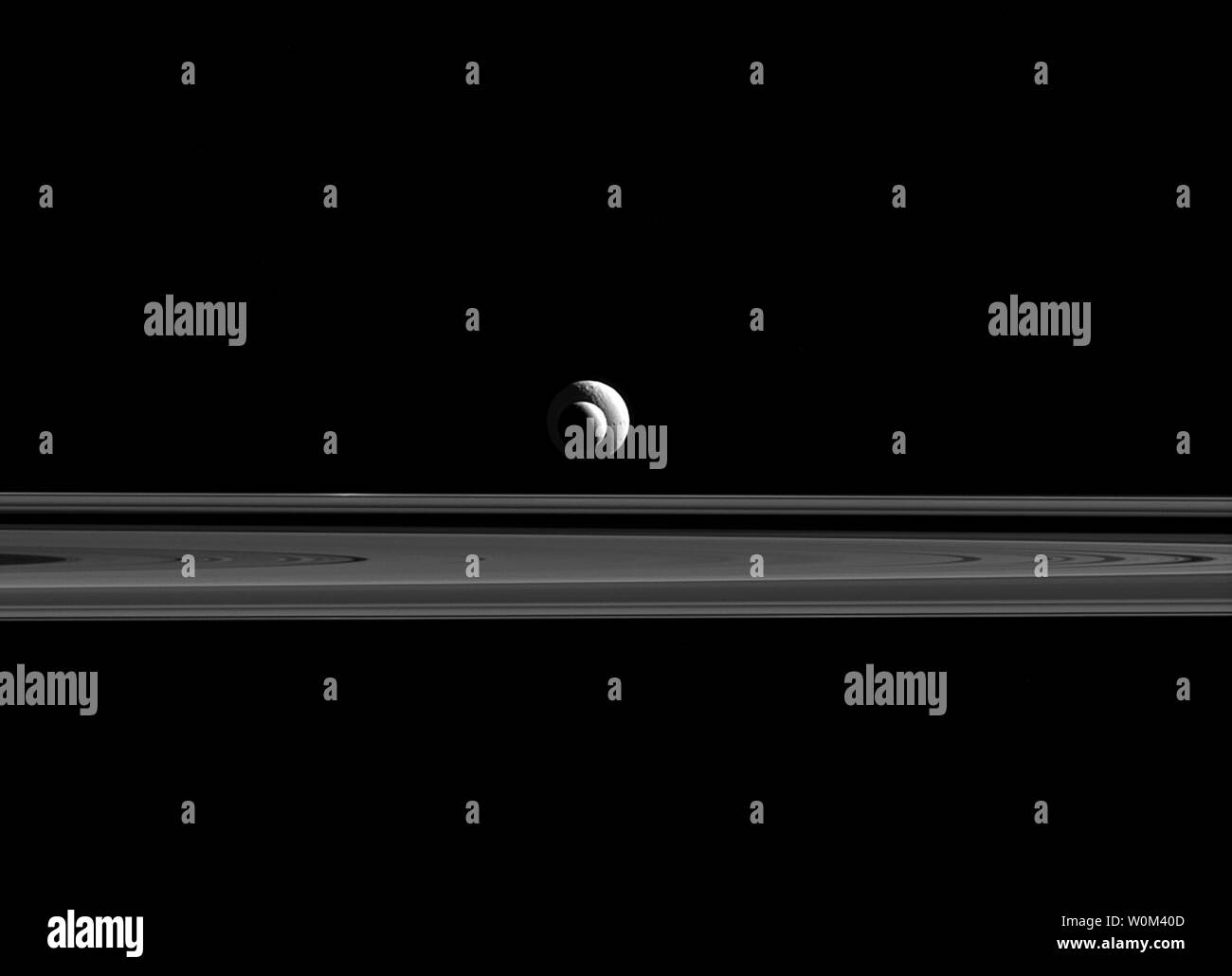 Wie eine kosmische Bullauge, Enceladus und Tethys Line up fast perfekt für Cassini Kameras. Da die beiden Monde nicht nur, aber auch bei relativ ähnlichen Entfernungen von Cassini, die scheinbaren Größen in diesem Bild ausgerichtet werden, sind eine gute Annäherung an die relativen Größen von Enceladus (313 Meilen oder 504 Kilometer Durchmesser) und Tethys (660 Meilen oder 1.062 Kilometer Durchmesser). Diese Ansicht, in rotes Licht am 24. September 2015 getroffen, schaut in Richtung der unbeleuchtet Seite der Ringe von 0,34 Grad unterhalb der Ringebene. Am 15. September 2017, nach zwei Jahrzehnten im Raum, der NASA-Raumsonde Cassini seine gemacht Stockfoto