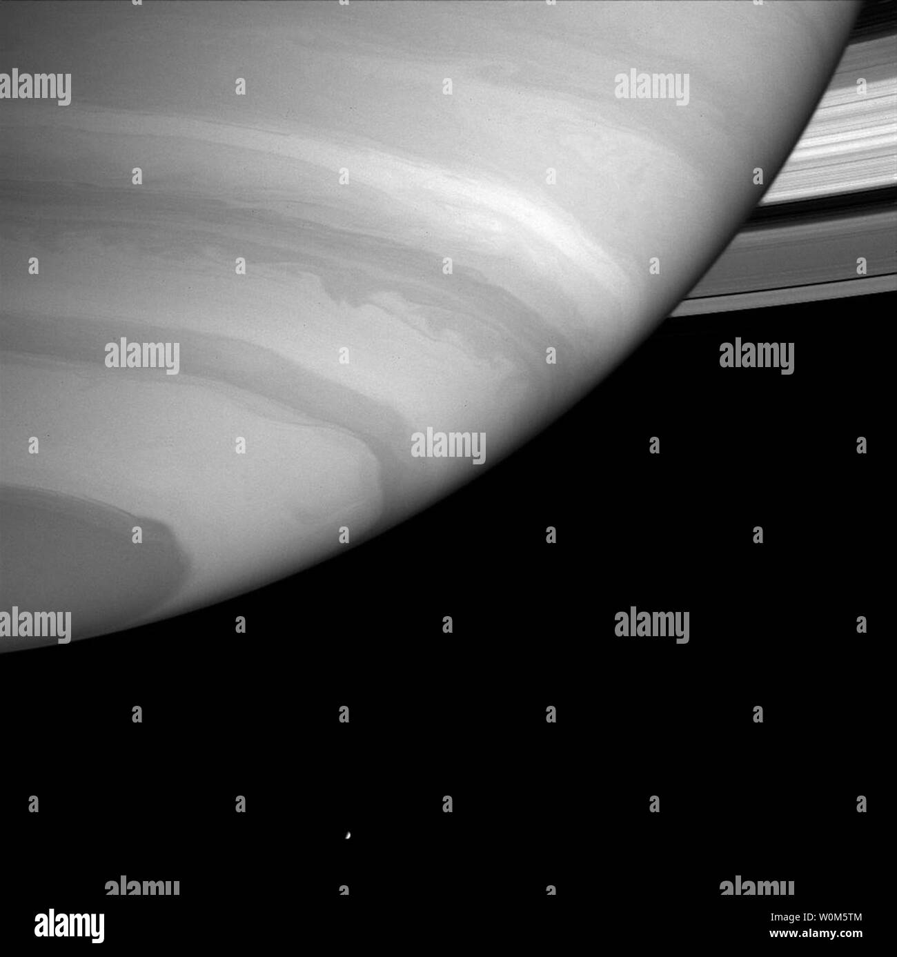 Saturn wird die südliche Atmosphäre webstühle vor Cassini, die Anzeige von Details in seinen Strudel und Bands. Die hellen, Eismond Enceladus (499 Kilometer oder 310 Meilen über) erscheint am unteren Rand des Bildes. Diese Ansicht wurde durch ein Filter, in denen Methangas ist eine moderate Absorber von Sonnenlicht. Da Methan Gas nicht auf Enceladus vorhanden ist, seine Oberfläche streut einen höheren Prozentsatz der Licht als Saturn sieht, und der Mond scheint sehr hell im Vergleich zu den Planeten. Enceladus wurde in der Helligkeit um den Faktor vier während der Verarbeitung des Bildes gedimmt, um zu seiner zu machen Stockfoto