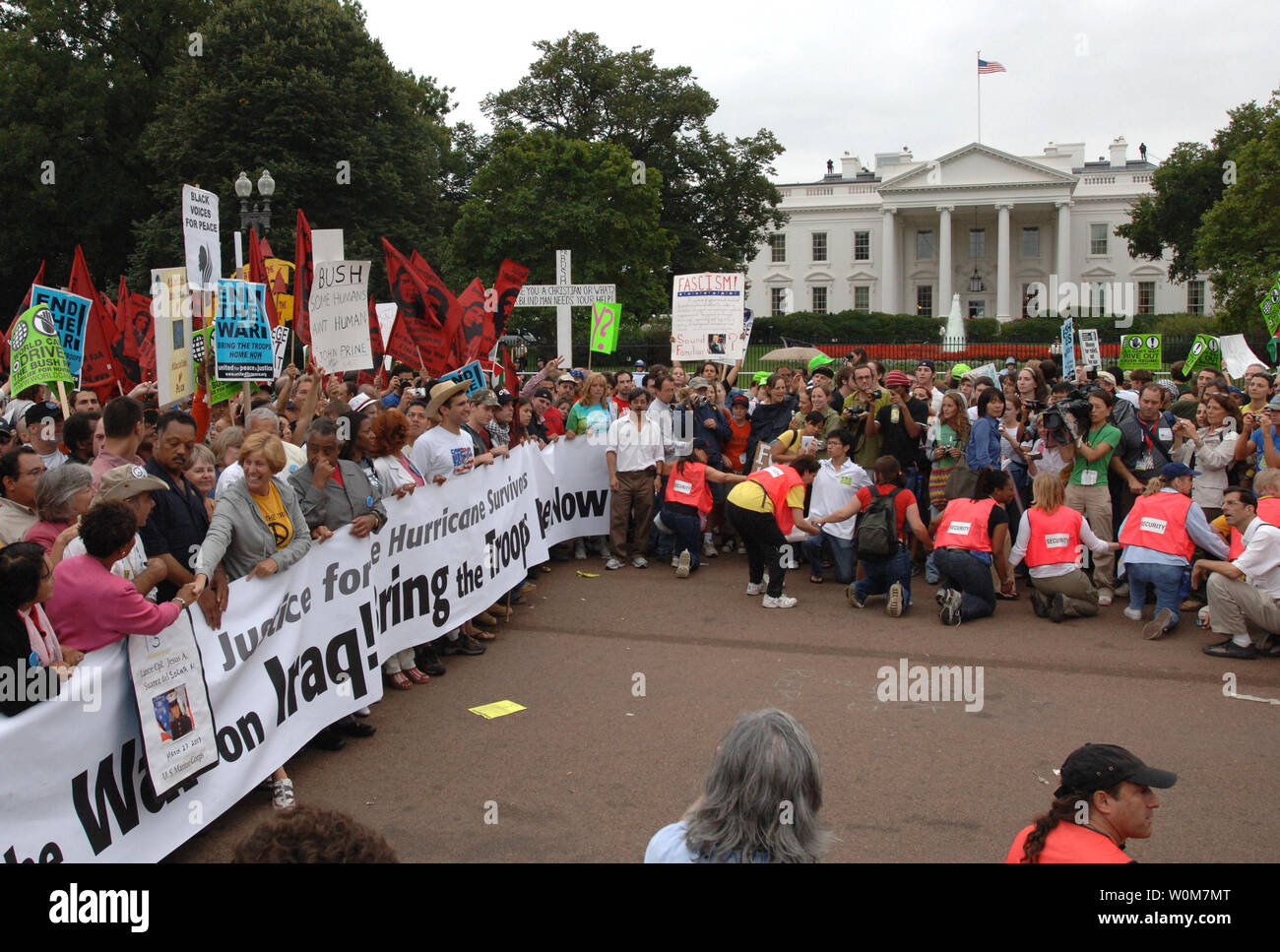 Cindy Sheehan schüttelt Hände mit einem Gefährten demonstrant als Rev. Jesse Jackson (C) sieht, dass Sie bei einem kurzen Stopp der Anti-kriegs-März vor dem Weißen Haus in Washington am 24. September 2005. Zehntausende von Demonstranten gegen den Irakkrieg. (UPI Foto/Pat Benic) Stockfoto