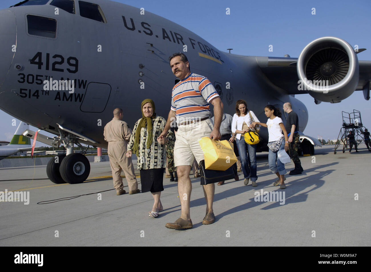 Airman 1st Class Jarod Lambert, Lademeister, hilft Reisenden mit dem Bus nach dem Aussteigen einen C-17 Globemaster Flugzeuge an der Air Base Ramstein, Deutschland Am 23. Juli 2006 finden. Nach 99 Amerikanische citrizens in Zypern aus dem Libanon, Mitglieder des 16 Air Lift Squadron, Charleston, S.C., vorausgesetzt Sie Transport auf Deutschland durch eine C-17 Globemaster Flugzeuge. Das C-17-Crew war der erste Air Force aircrew Team amerikanischer Bürger aus dieser Region zu Luftbrücke, und wird dies auch weiterhin tun, bis alle Amerikaner, die wünschen, den Libanon zu verlassen untergebracht sind. (UPI Foto/Stacy L. Birnen Stockfoto