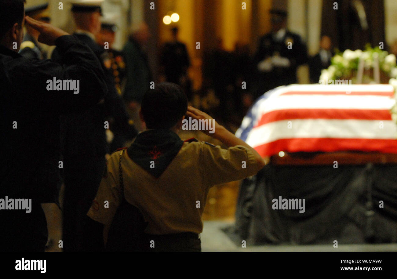 Ein Kind, in einem Pfadfinder Uniform gekleidet, und sein Vater grüßen die Schatulle von Präsident Gerald R. Ford, 38. Präsident der Vereinigten Staaten, als er liegt im Staat, in der Rotunde des United States Capitol am 31. Dezember 2006. (UPI Foto/Alexis C Glenn) Stockfoto