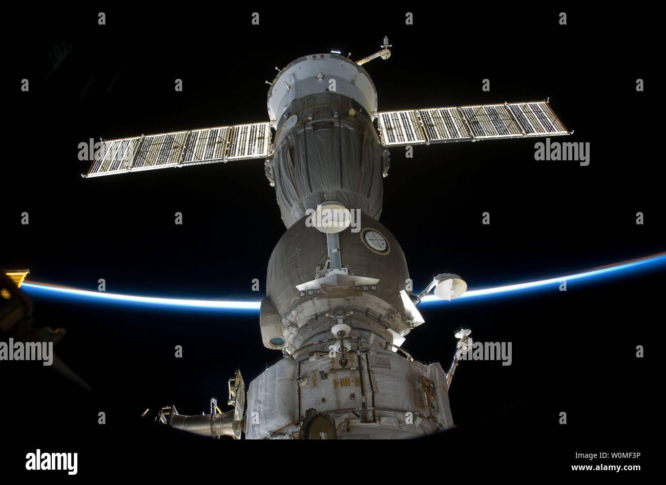 S127 - E -008664 (25 Juli 2009) - - - die Extremität der Erde kreuzt eine von zwei Sojus-kapsel, mit der Internationalen Raumstation angedockt sind, wie die Crew der STS-127 Space Shuttle Endeavour die Internationale Raumstation angedockt sind die japanische Experimentmodul exponierten Standort zu installieren. (UPI Foto/NASA) Stockfoto