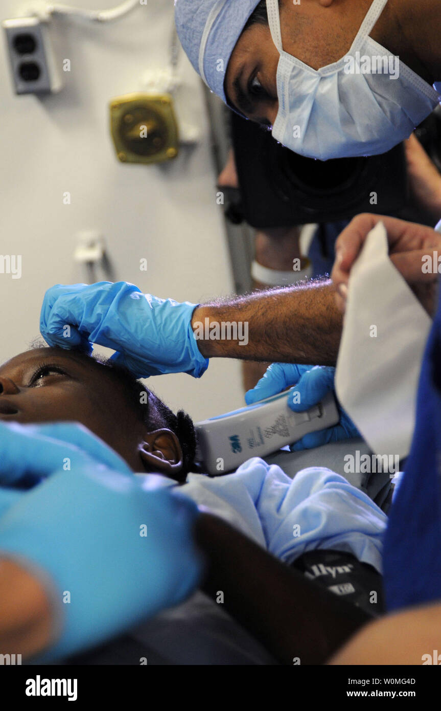 Dr. Sanjay Gupta, einer CNN-medizinische Korrespondent und üben Neurochirurg, bereitet eine 12-jährige Haitianischen Mädchen mit einer schweren Kopfverletzung für Chirurgie an Bord der Nimitz-Klasse Flugzeugträger USS Carl Vinson (CVN 70) in der Nähe von Port-Au-Prince, Haiti, am 18. Januar 2010. Chirurgen entfernt ein Stück Beton vom Gehirn des Kindes durch das Erdbeben in Haiti verursacht. UPI/Michael Barton/U.S. Marine Stockfoto
