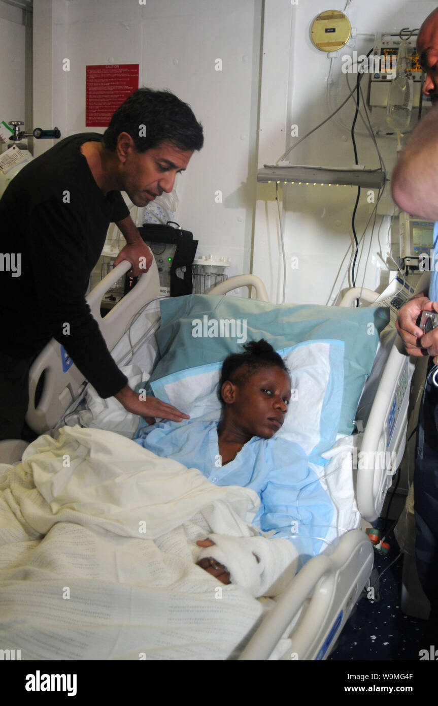 Dr. Sanjay Gupta untersucht einen verletzten Haitianerin in der medizinischen Einrichtung an Bord der Nimitz-Klasse Atom-Flugzeugträger USS Carl Vinson (CVN 70) in der Nähe von Port-Au-Prince, Haiti, am 18. Januar 2010. Gupta, ein praktizierender Neurochirurg und Reporter für den CNN News Network, wurde zum Schiff brachte für die Durchführung der Operation am Gehirn auf eine 12-jährige Hatian Mädchen zu unterstützen. UPI/Erin Oberholtzer/U.S. Marine Stockfoto