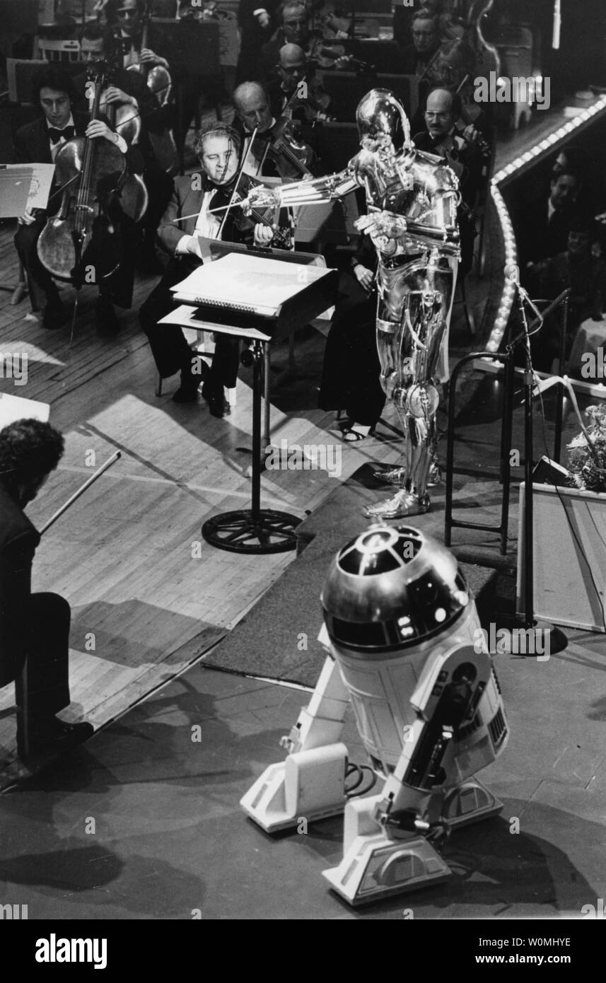 4. Mai ist die inoffizielle Urlaub von Star Wars Fans die Kultur durch das Wahrzeichen Filme zu feiern. Basierend auf der beliebten Zitat aus der Filme, 'Möge die Macht mit dir sein", Fans sagen häufig 'May das vierte mit Euch sein" an diesem Tag. In diesem UPI Foto, C-3PO (hinten) eine menschliche Form protocol Droid mit seiner engen Mitarbeiter, R2-D2 an seiner Seite, führt die Boston Pops Orchestra als die beiden Droiden aus tar des Films Wars" das Debüt von John Williams als Dirigent des Pops in der Symphony Hall am 29. April 1980 teil. Williams schrieb die ursprüngliche Kerbe für alle sechs Star Wars f Stockfoto