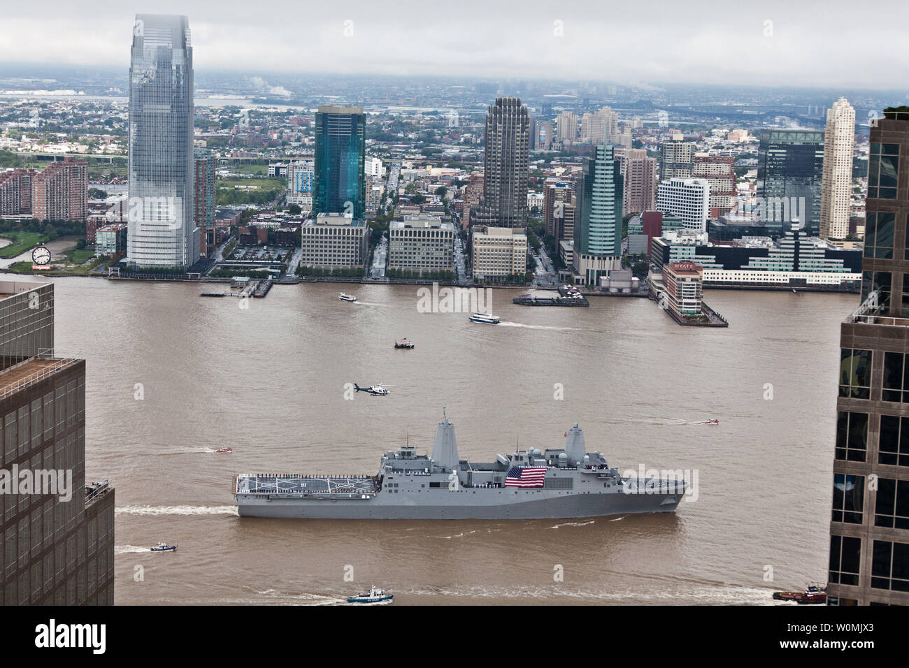 Mitglieder der Besatzung an Bord der amphibious Transport dock Schiff USS New York (LPD 21) die Schienen und Gegenwart ehren Mann während des World Trade Center und den Nationalen September 11 Memorial und Museum, wie das Schiff in Manhattan am 8. September 2011 eintrifft. An Bord sind die Familienangehörigen der Opfer und Rettungskräfte von 9/11, zusammen mit der Crew und Marines in den dritten Bataillon zugeordnet, 9 Marine Regiment. New York war mit 7,5 Tonnen Stahl von Ground Zero wieder errichtet. Am Sept. 11, New York Transit aus seiner Verankerung in den Hudson River nach einer Lage mit Blick auf das World Trade Cente Stockfoto