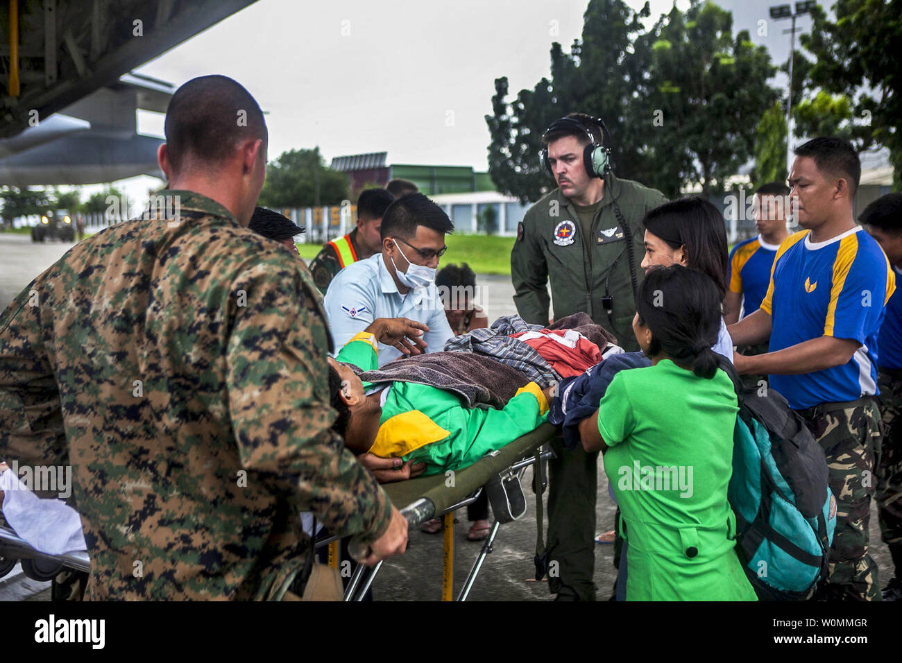 Us Marine Staff Sgt. Jacques Mason, US Marine Cpl. Zachery Stapf, Hilfe offload Eine verletzte Filipino zivile aus einem Marine Hercules C-130 Flugzeugen an Villamor Air Base, in den Philippinen, November 12,2013, wie sie bei Hilfsmaßnahmen in der Folge des Taifuns Hiyan unterstützen. Us-Militärs sind die Unterstützung der philippinischen Streitkräfte bei der Bereitstellung humanitärer Hilfe und Katastrophenhilfe in den betroffenen Bereichen in den Philippinen nach der tödlichen Taifun, die 2.357 toten Links. UPI/Codey Underwood/USMC Stockfoto