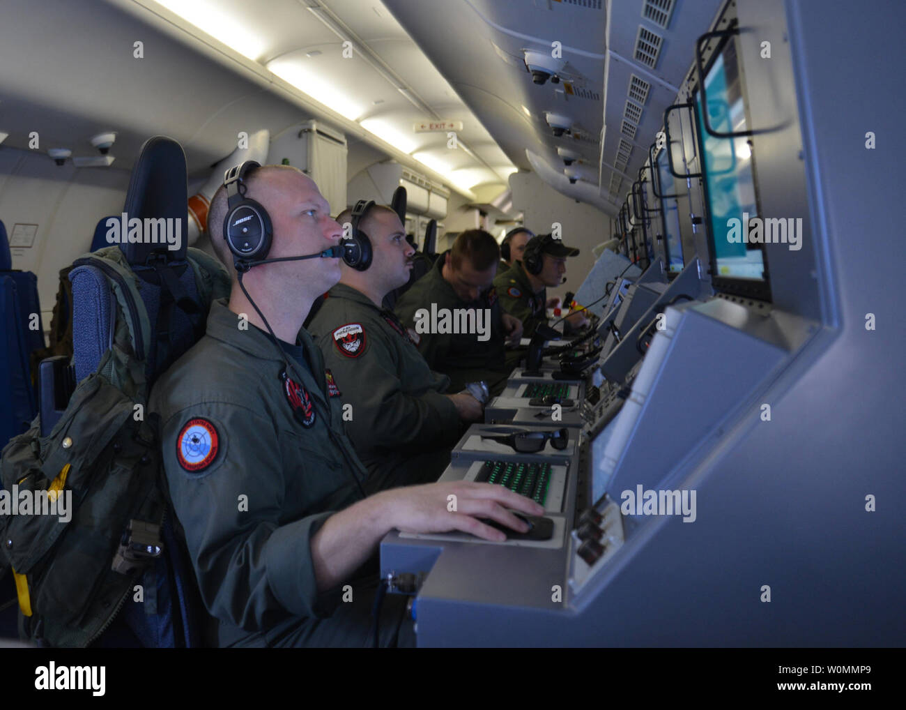 Die Mitglieder der Besatzung an Bord eines P-8A Poseidon zu patrouillieren Squadron (VP) 16 Mann ihren Workstations bei der Unterstützung der Such- und Rettungsmaßnahmen für Malaysia Airlines Flug MH370, über dem Indischen Ozean, 16. März 2014 zugeordnet. Die Suche wurde nach einer Woche langen Suche im Chinesischen Meer fehlgeschlagen Ergebnisse erweitert. UPI/Eric A. Pastor/US Navy Stockfoto