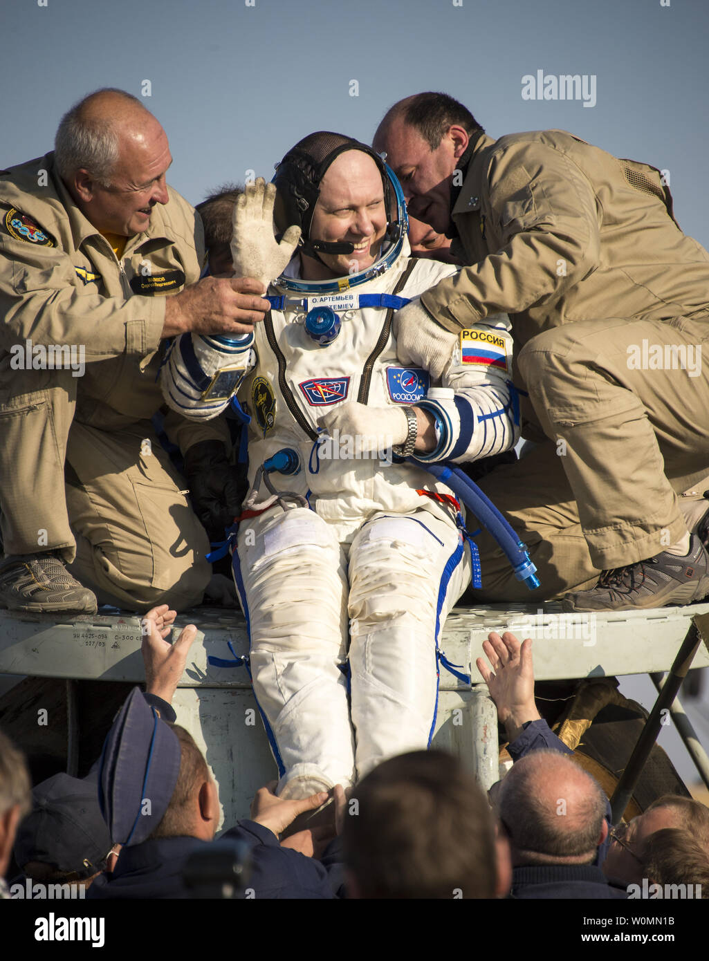 Expedition 40 Bordingenieur Oleg Artemyev der russischen Föderalen Raumfahrtagentur (Roskosmos) Wellen, als er aus dem sojus Kapsel geholfen wird, nur wenige Minuten nachdem er und Bordingenieur Alexander Skvortsov von Roskosmos und Expedition 40 Commander Steve Swanson der NASA, in der Sojus TMA-12M Kapsel in einer abgelegenen Gegend in der Nähe der Stadt Zhezkazgan, Kasachstan landete am 11. September 2014. Swanson, Skvortsov und Artemyev wieder auf der Erde Nach mehr als fünf Monaten an Bord der Internationalen Raumstation, wo sie als Mitglieder der Expedition 39 und 40 Mannschaften serviert. UPI/Bill IngallsNASA Stockfoto