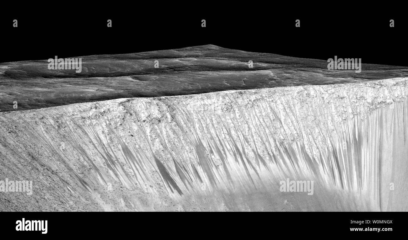 Dunkle schmale Streifen, genannt 'curring Hang lineae", stammen aus den Wänden der Garni Krater auf dem Mars, in dieser Ansicht aus Beobachtungen von der High Resolution Imaging Science Experiment (HiRISE-Kamera der NASA Mars Reconnaissance Orbiter gebaut, es wurde von der NASA am 28. September angekündigt, 2015 in Washington, DC. Die dunklen Streifen sind hier bis zu einigen hundert Yards, oder Meter, lang. Sie sind es, die durch den briny flüssiges Wasser auf dem Mars gebildet werden. Das Bild wurde durch den ersten Erstellen einer 3D-Computermodell (a digital Terrain map) Der Bereich auf stereo Informationen aus zwei HiRI produziert Stockfoto
