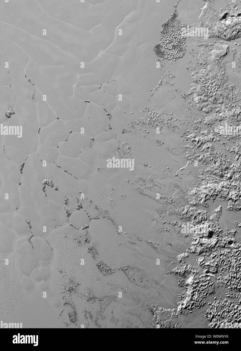 Der Stickstoff Eis Gletscher auf Pluto erscheinen zu tragen eine faszinierende Cargo: Zahlreiche, isolierten Hügel, die Fragmente von Wassereis von Plutos umliegende Hochland. Diese Hügel individuell messen ein bis mehrere Meilen oder Kilometer nach Bilder und Daten von Nasas "Neue Horizonte der Mission am 14. Juli 2015 ... Die Berge, die in der riesigen Eis plain informell namens Sputnik Planum innerhalb von Pluto 'Herz', wahrscheinlich sind verkleinerte Versionen der größeren, durcheinandergebracht Bergen auf der Sputniks Planum westlichen Grenze. Sie sind ein weiteres Beispiel für Plutos faszinierende und reichlich vorhandenen geologischen Akt Stockfoto