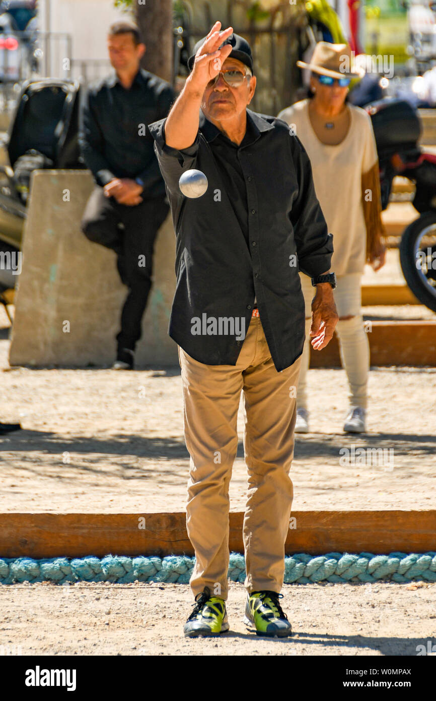 CANNES, Frankreich - April 2019: Mann warf eine Boule in einer Partie Boule auf einem sandigen pitch Bereich in Cannes Stadtzentrum Stockfoto