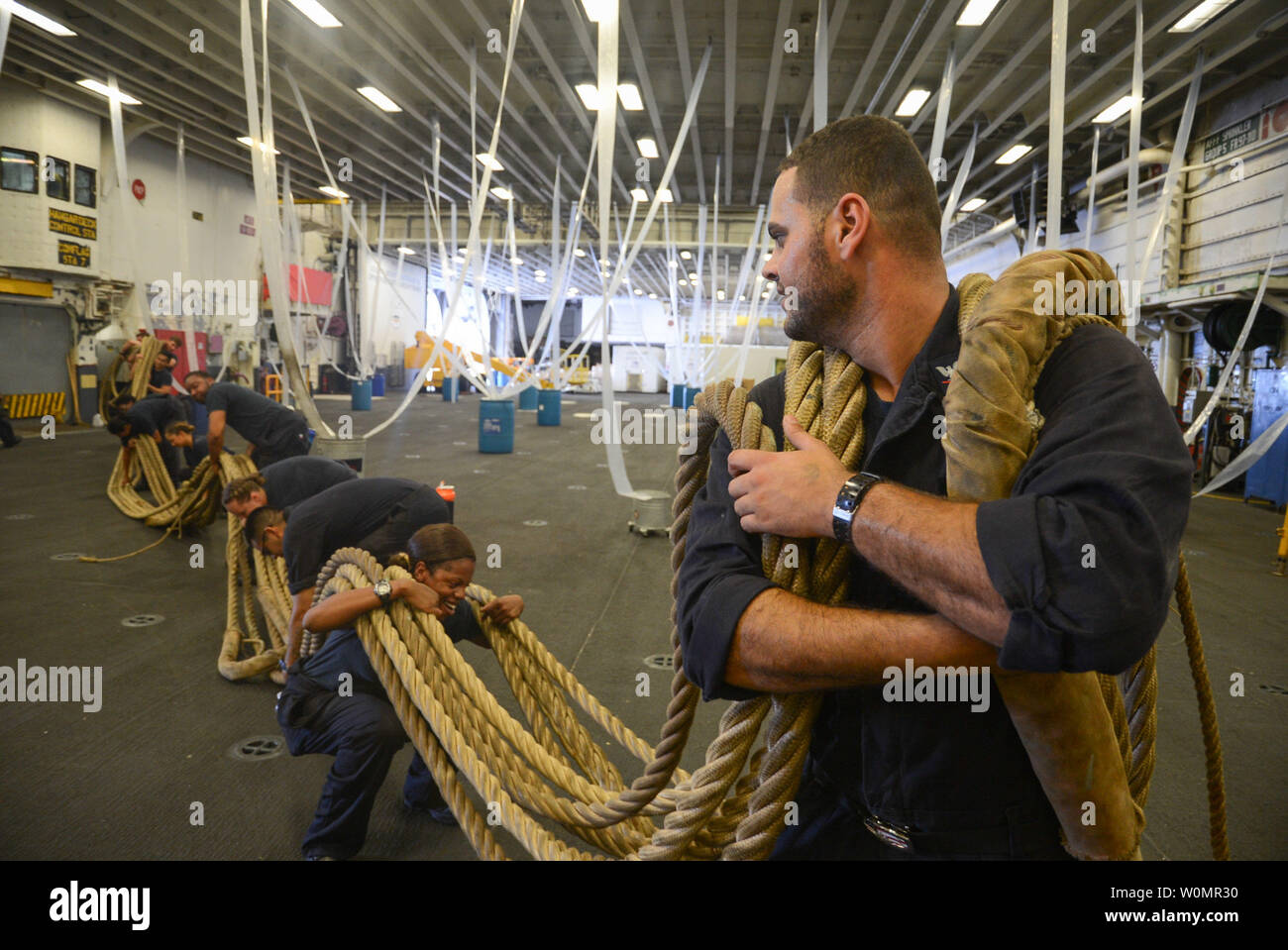 BoatswainÕs Mate 3. Klasse Ahmed N. Abdarbo führt eine Gruppe von Matrosen Transport ein Bündel der Verlagerung der Leitungen durch den Hangar Bay an Bord amphibisches Schiff USS Iwo Jima (LHD7) am 1. September 2016. Iwo Jima ist wieder folgende Übung Bold Alligator 2016 zu ihrem Heimathafen der Mayport, Fla. Foto von Jered C. Wallem/U.S. Marine/UPI Stockfoto