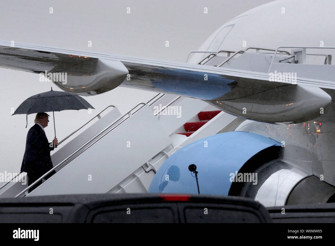 Us-Präsident Donald Trump geht die Treppe hinauf in den Regen, wie er Boards Air Force One am 28. Juli 2017 einen Joint Base Andrews, Maryland. Trump ist Reisen in Ronkonkoma, New York, Erläuterungen zur Durchsetzung von Rechtsvorschriften zu geben. Foto von Chip Somodevilla/UPI Stockfoto