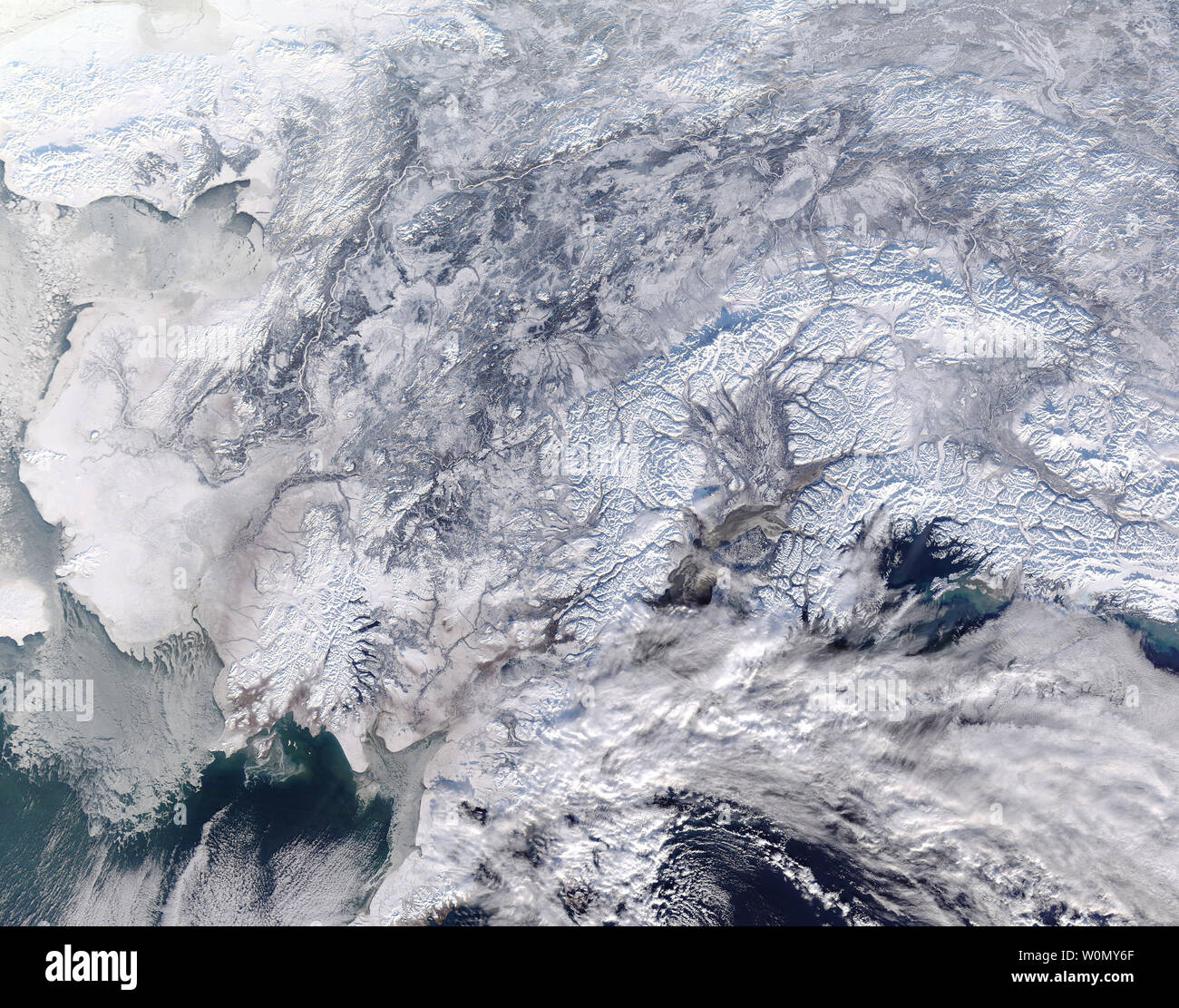 Alaska war in der vollen Griff der Winter am 31. Januar 2018, wenn die NASA-Satelliten Terra bestanden Overhead. Die Moderate Resolution Imaging Spectroradiometer (MODIS) Fliegen an Bord erworben. true-color Bild von einem Teil der südlichen Alaska am selben Tag und zeigt eine Szene gut im Winter weiß bedeckt.. Schnee bedeckt das Land von Nome, der in der Nähe der westlichen Grenze des Bildes sitzt, an der Grenze zu Kanada im Osten. Meereis klammert sich an die Küste im Westen, schwebend über die Gewässer von Bristol Bay. Heavy cloud Bögen über den Golf von Alaska im Südosten, wahrscheinlich zusätzlich bringen. Stockfoto