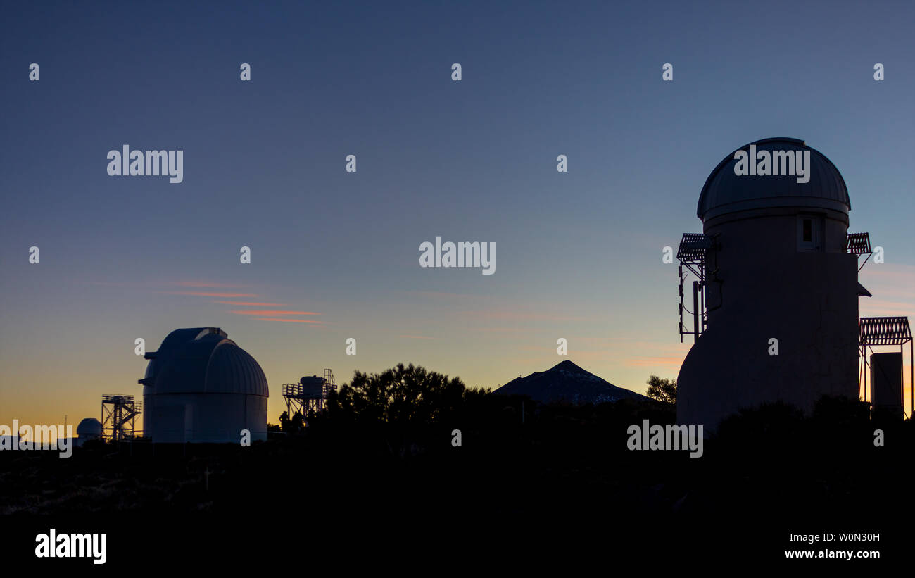 Silhouetten von Teleskopen in einem professionellen astronomischen Sternwarte bei Sonnenuntergang warten, um den Himmel zu beobachten Stockfoto