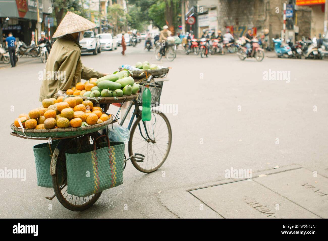 Unbekannter Mann treibt ein Fahrrad mit Körben in Hanoi, Vietnam. Straße Vending durch Bike ist ein wesentlicher Bestandteil des Lebens in Vietnam. Stockfoto