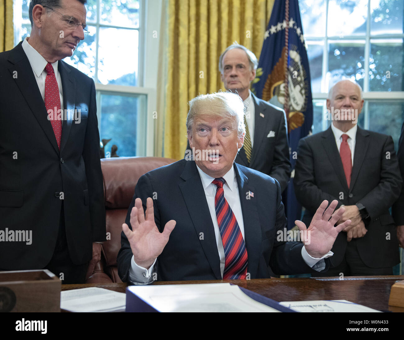 Präsidenten der Vereinigten Staaten Donald J. Trumpf spricht mit der Presse Pool nach der Unterzeichnung S. 3021, Amerikas Infrastruktur Wasser Act von 2018 im Oval Office des Weißen Hauses in Washington, DC am Dienstag, 23. Oktober 2018. Der Präsident nahm Fragen aus dem Pool auf dem Caravan und Saudi Arabien. Auf der Suche nach Links sind: US-Senator John barrasso (Republikaner von Wyoming), US-Senator Tom Carper (Demokrat von Delaware), US-Senator Ben Cardin (Demokrat von Maryland). Foto von Ron Sachs/UPI Stockfoto