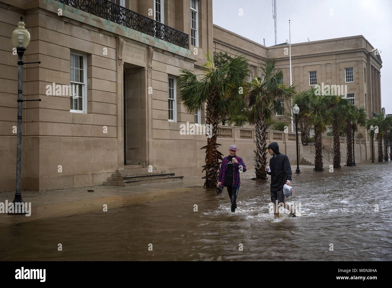 Leute trinken Bier, wie Sie durch eine teilweise überfluteten Innenstadt entfernt, wie der Cape Fear River fließt in die South Water St., nachdem Hurrikan Florenz Landfall, 14. September 2018 in Wilmington, North Carolina. Foto von Al Drago/UPI Stockfoto