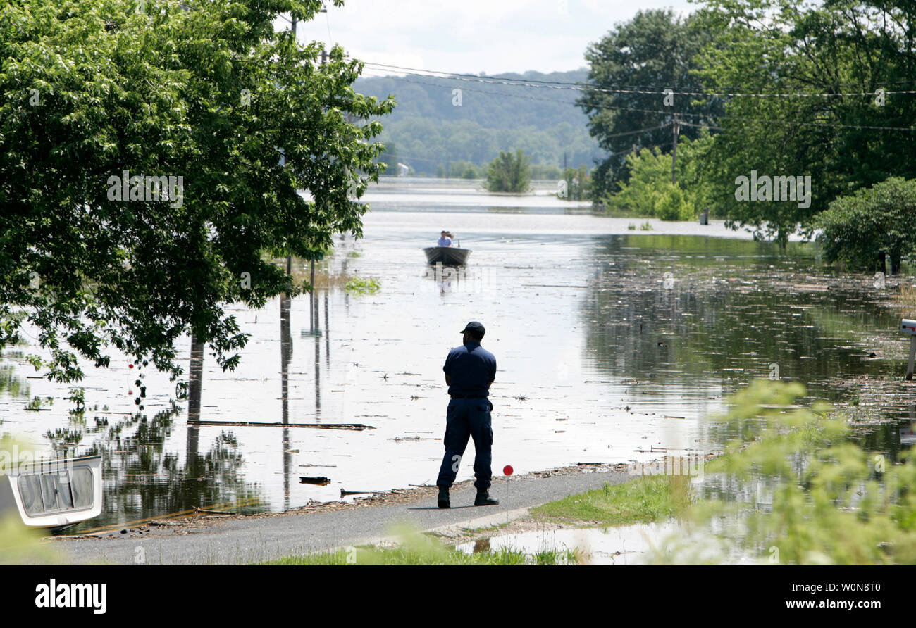 Ein Mitglied der Küstenwache Uhren ein Boot nehmen, ein Bewohner von Winfield, Missouri, in ihre Heimat, den 20. Juni 2008. Hilfsmaßnahmen zentriert auf up Traggerüst sekundäre Deiche nach den Mississippi River brach es Banken. (UPI Foto/Markierung Cowan) Stockfoto