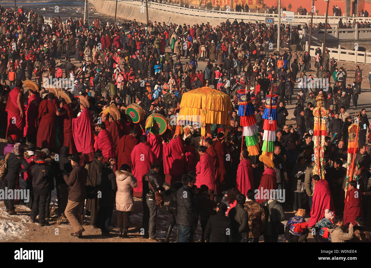 Tibetische Mönche tragen eine riesige Thangka Buddha, oder Wandteppich, auf einen Berg in der Nähe des Klosters Labrang, das größte tibetische Kloster außerhalb von Lhasa, während die tibetischen Monlam Festival in Xiahe, einer kleinen Stadt in der Provinz Gansu auf dem tibetischen Plateau, 4. Februar 2012. Tausend tibetischer Mönche, Pilger und Nomaden haben auf das Kloster converged für die jährliche Ausführen von Ritual der Buddha', in dem die weltweit größte Thangka Buddha (90 m Länge, 40 m Breite) an der ersten Ampel auf der Seite eines Berges enthüllt ist. Das monlam fest, oder große Gebet Festspiele, ist die größte religiöse Stockfoto