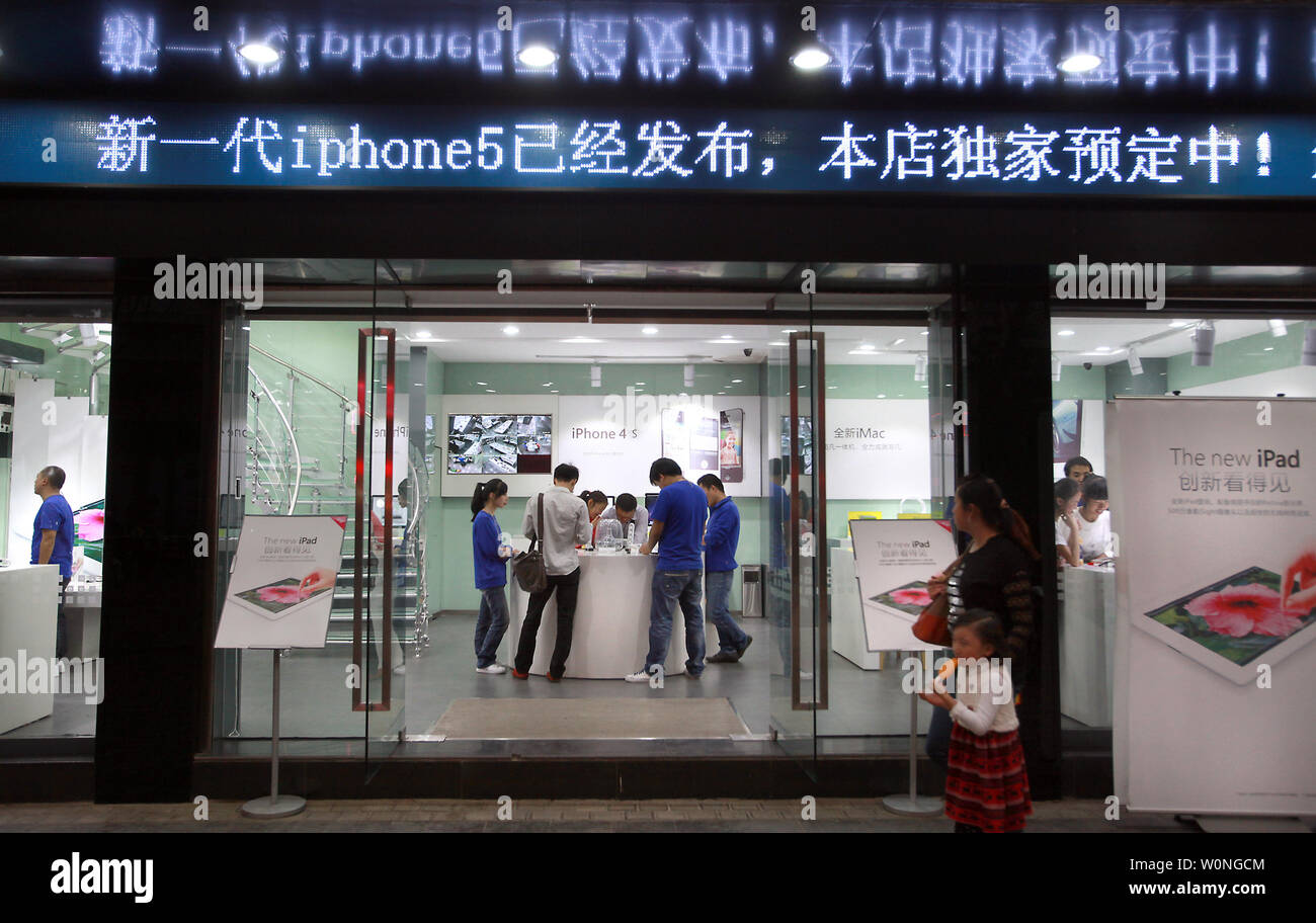 Chinesische Mitarbeiter als offizielle Apple Mitarbeiter arbeiten an einem Computer Store selbst schamlos ankündigen als offizieller "Apple Smart Store gekleidet, 'Verkauf Kunden real und "grauen" Produkte von Apple in Kunming, der Hauptstadt der Provinz Yunnan, am 24. September 2012. Kunming hat mehrere 'Apple' speichert einzustellen und im letzten Jahr unterlassen haben, offen missachten Urheberrechte und Warenzeichen Verstöße. Wie der Fall steht, viele Male ein Erscheinen der Kraft, die von der Regierung in Angriff zu nehmen, solche Probleme zu lösen und ist in der Regel nur temporär um die ansprecher zu beschwichtigen. UPI/Stephen Rasierer Stockfoto