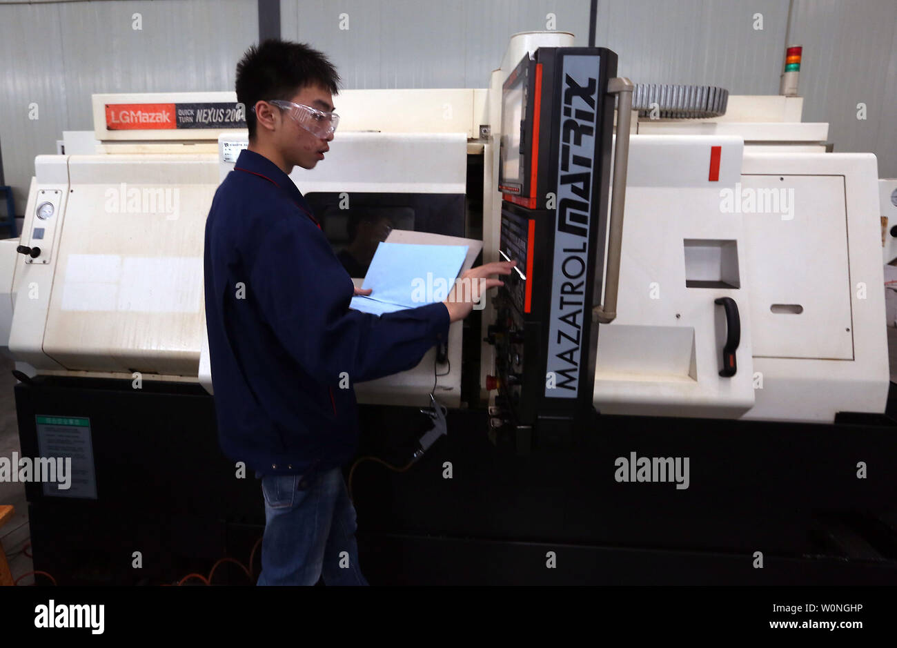 Eine Chinesische Techniker überwacht die präzises Bohren der Luftfahrt Gasturbine Komponenten durch Software-gesteuerte Maschinen Hanyu der Produktionsstätte in Zigong, Provinz Sichuan, am 16. November 2017. Hanyu produziert Schlüsselkomponenten für Luftfahrt und Gasturbinenschaufeln, von denen einige militärische sind ab und sind in die Vereinigten Staaten exportiert. Foto von Stephen Rasierer/UPI Stockfoto