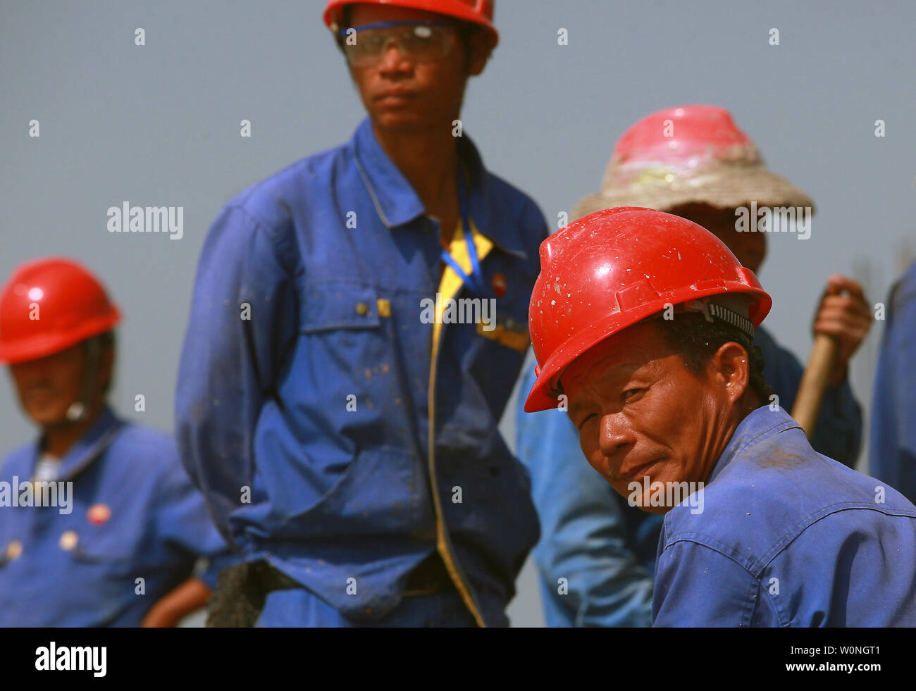 Chinesische Arbeiter machen Sie eine Pause in der Nähe von Kraftstoff Außenlager und eine tiefe Wasser flüssig gas-Anlage in der Still-Unterkonstruktion Jailan Port, eine große umfassende Hafen Industrie Zone, in Zhuhai, einer größeren Stadt am Pearl River in der südchinesischen Provinz Guangdong liegt am 26. Oktober 2013. Jailan port ist ein Setup der Schwer- und chemischen Industrie konzentrierte sich hauptsächlich auf die Herstellung von und zu einer bedeutenden petrochemischen und der Ausgangspunkt für die Auslagerung und Raffinesse. BP und Shell haben große Bereiche im Hafen zone eröffnet. Ressourcen, insbesondere Energie, hat oberste Priorität für Kinn werden Stockfoto