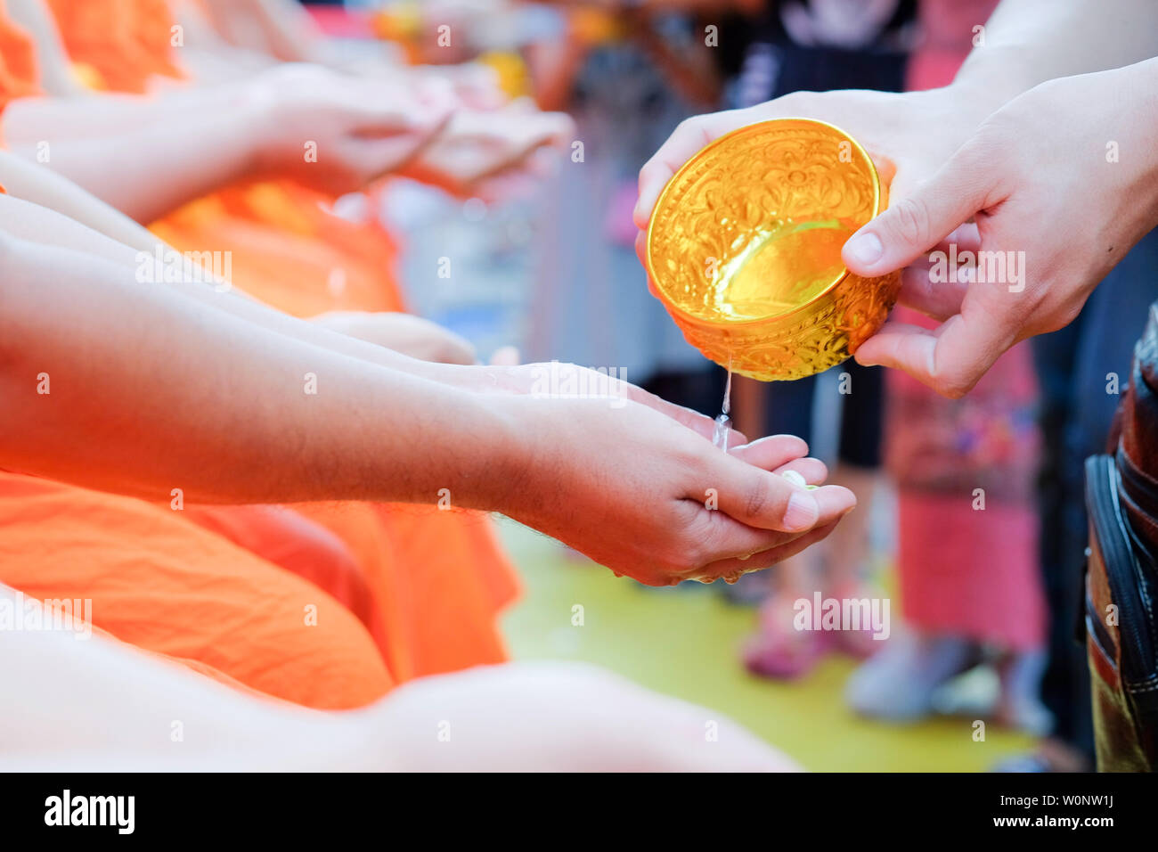Die Thais das Gießen von Wasser (Baden) an Hand der Mönch schließen, gießt Wasser ist eine der wichtigsten Zeremonien in Songkran Festival. Songkran Stockfoto