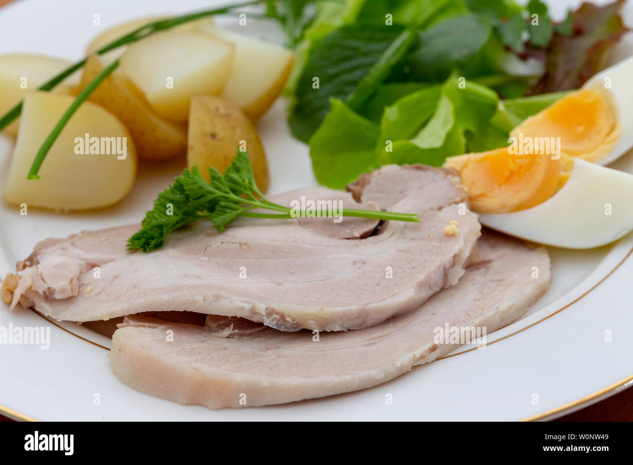 Schweinebraten Schichten mit Baby neue Kartoffeln einen grünen Salat und hart gekochte Eier Stockfoto
