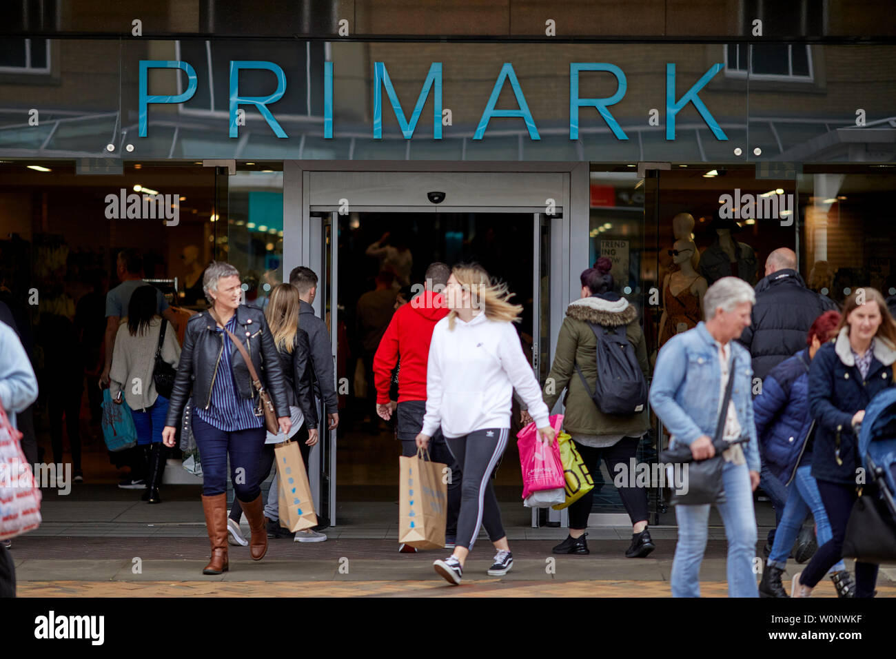 Shopper in Merseyway in Stockport Stadtzentrum Primark Eingang Stockfoto