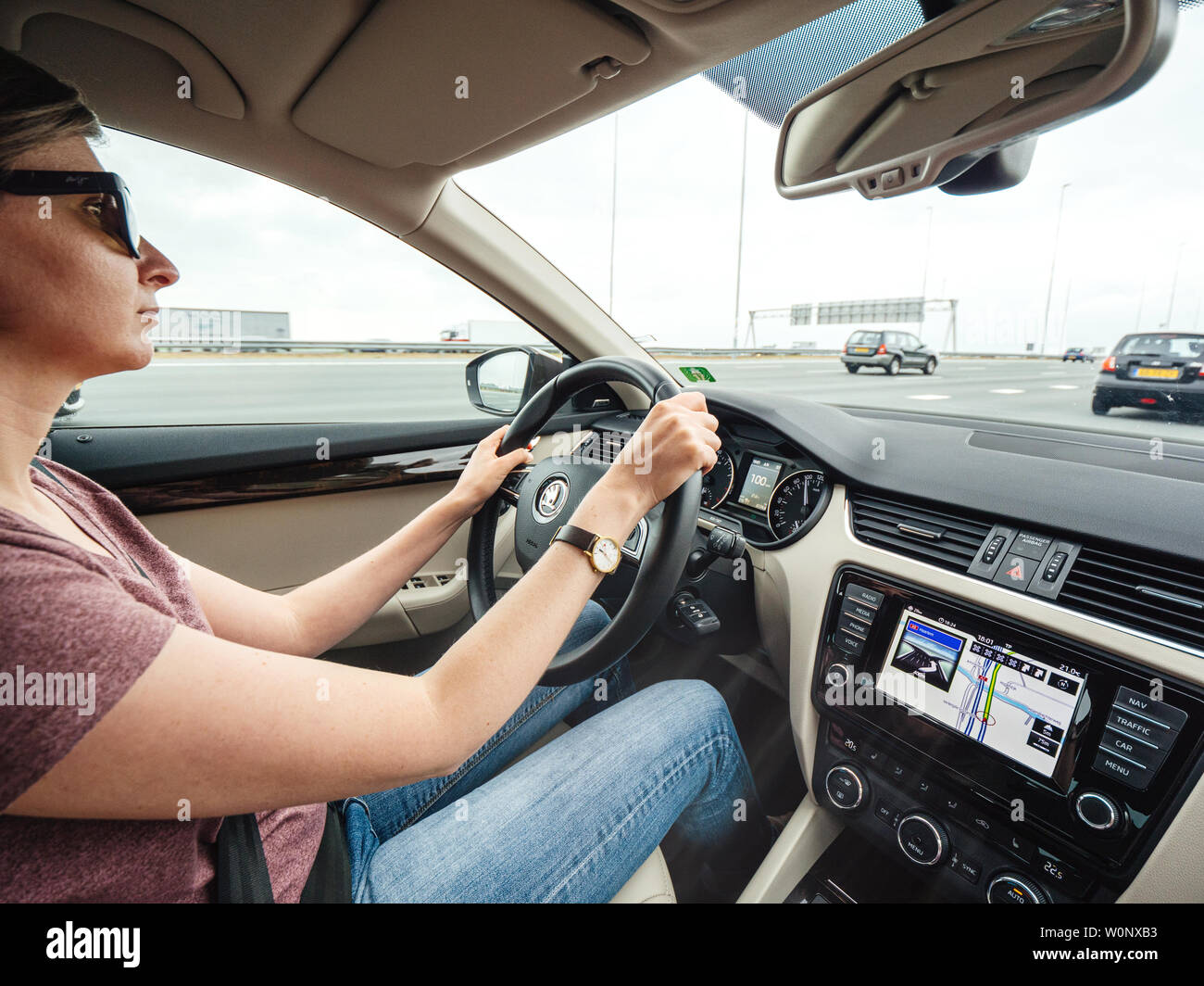 Haarlem, Niederlande - 15.August 2018: woman-driving Luxus Auto auf Niederländisch 6 spurigen Autobahn mit GPS-Anweisung auf dem Armaturenbrett Stockfoto