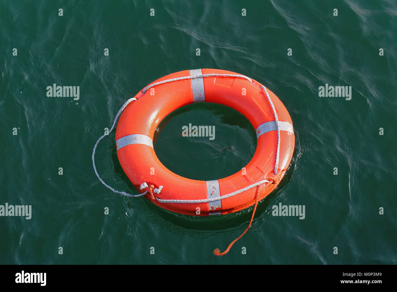 Orange Kreis Rettungsring schwimmt auf Wasser Oberfläche Stockfoto